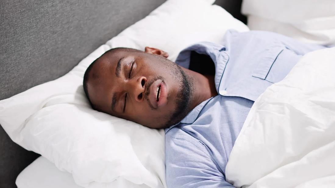 Man sleeping in bed with mouth open
