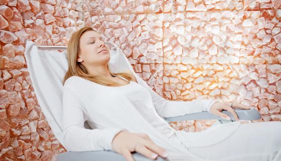 Person relaxing in a salt therapy room with salt rocks on the walls