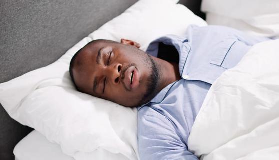 Man sleeping in bed with mouth open
